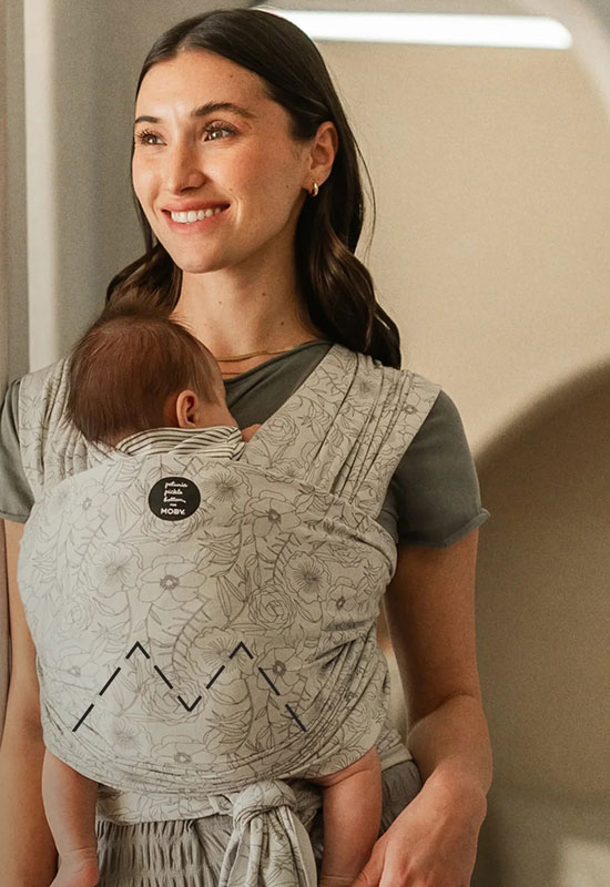 Mama trägt Baby im Classic Moby Wrap Seaside Poppies