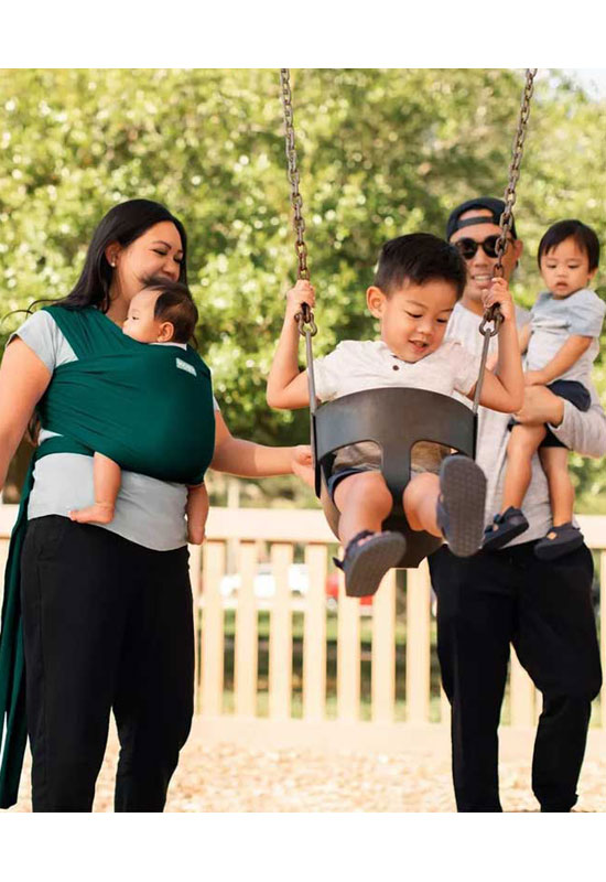 Papa und Mama tragen ihr Baby im Moby Classic Pacific